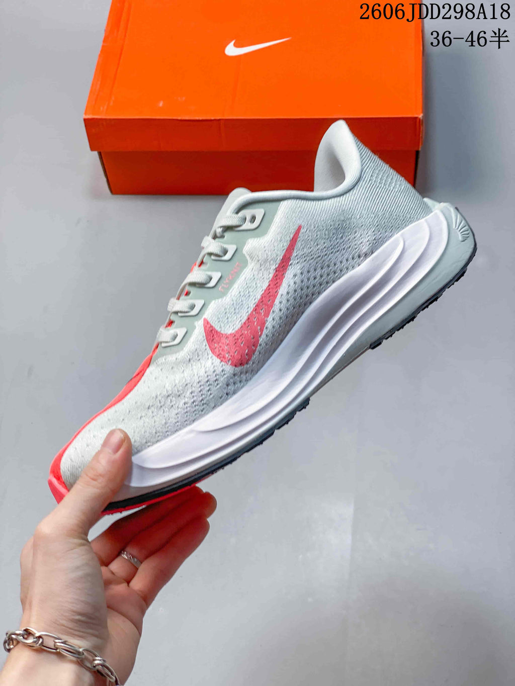 Side profile of the light grey running sneaker with a red Swoosh, white sculpted midsole, and black outsole edge.