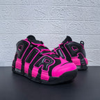 Front three-quarter view of the black and pink sneaker pair
