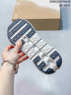Underside of a sneaker showing a sculpted white sole and dark tread sections.