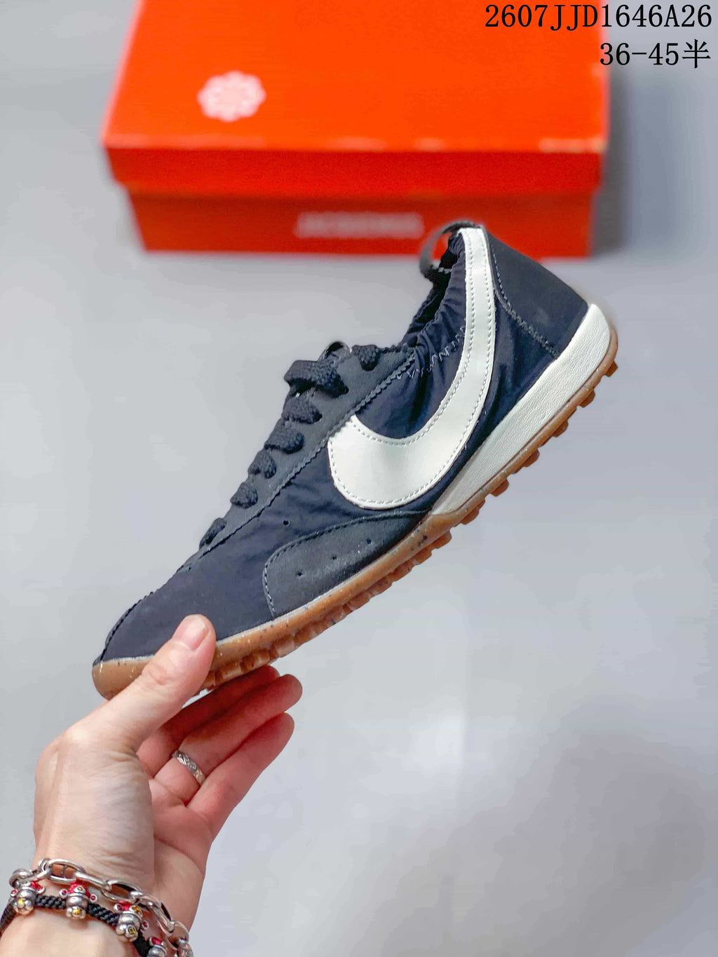 Side profile showing the dark low-top upper, large white Swoosh, white midsole, and gum outsole.