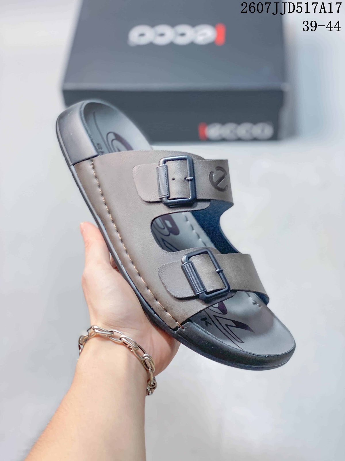 Close-up side view of a taupe-gray ECCO slide sandal with two adjustable buckles.