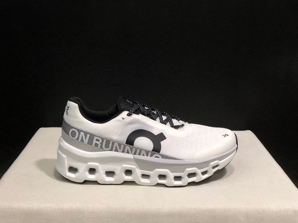Side profile of a white On Cloudmonster 2 shoe