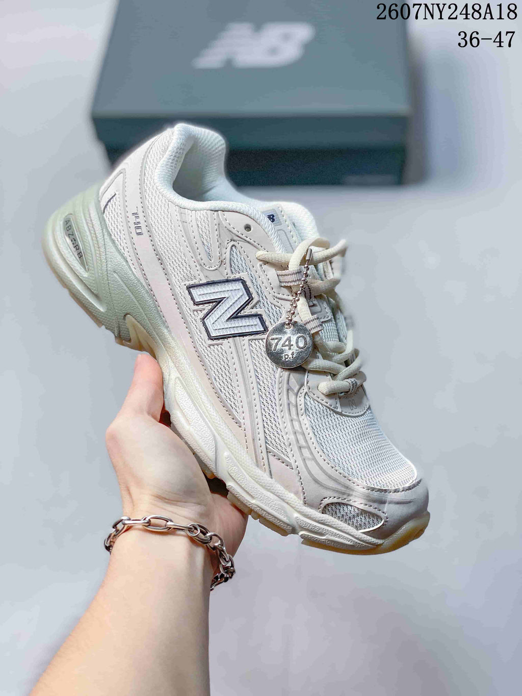 Off-white New Balance 740 sneaker with tonal panels and a visible 740 accessory.