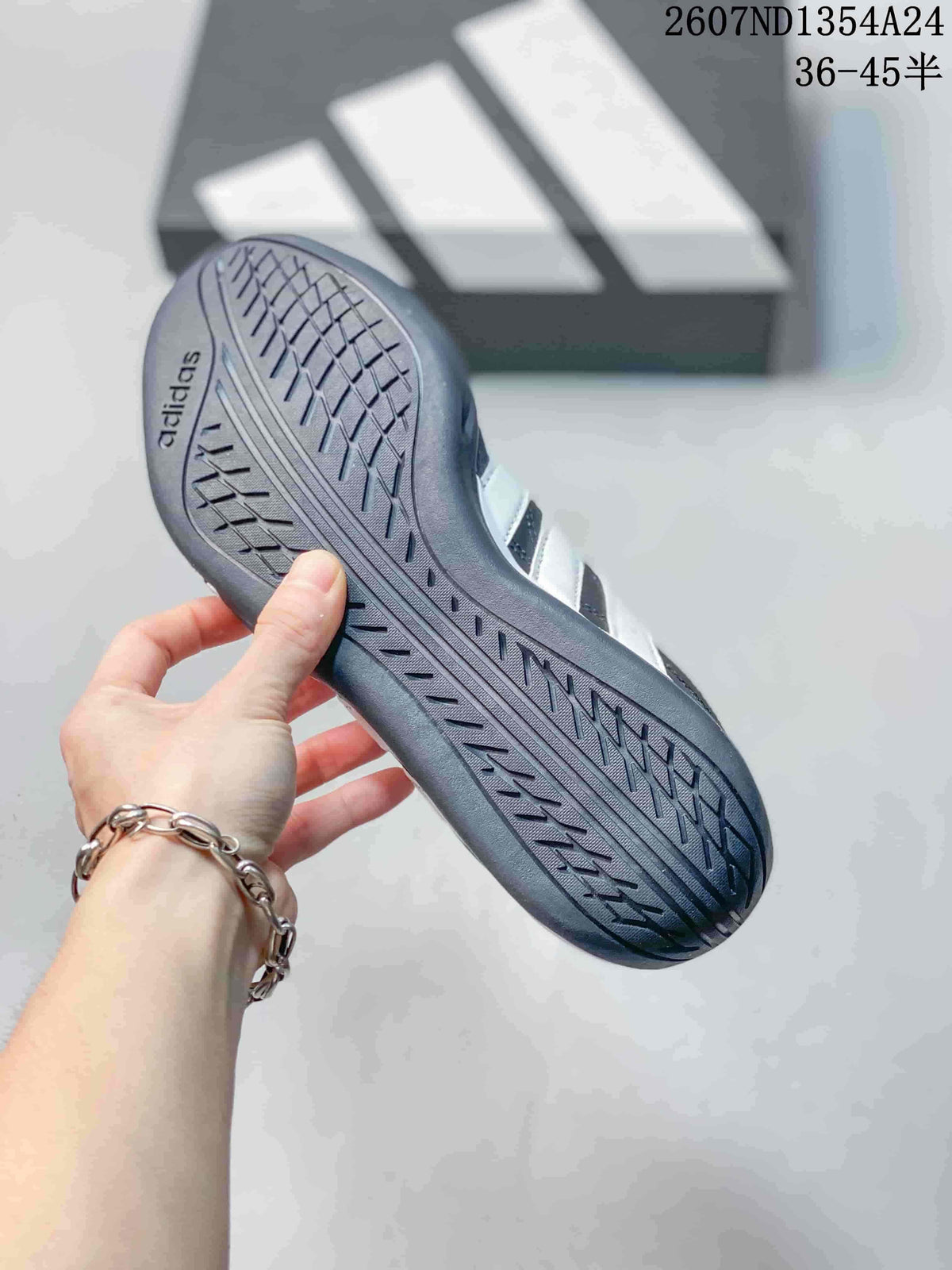 Close view of the patterned outsole on a dark adidas trainer.