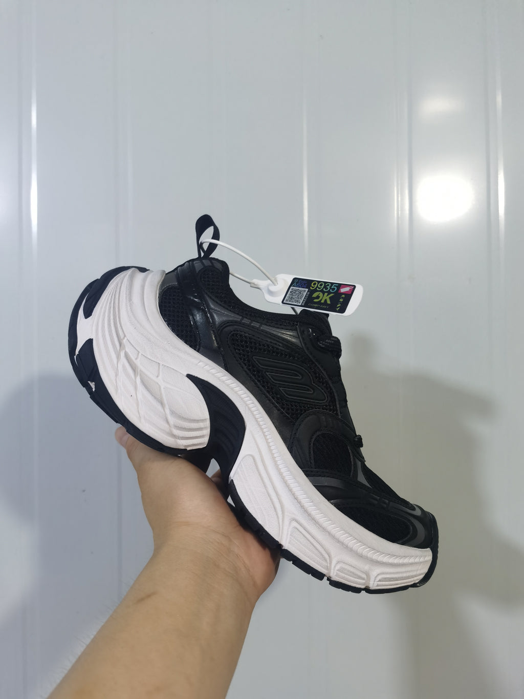 Black and white Skechers sneaker shown from the outer side, highlighting the layered upper and sculpted white midsole.