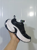 Black and white Skechers sneaker shown from the outer side, highlighting the layered upper and sculpted white midsole.