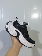 Black and white Skechers sneaker shown from the outer side, highlighting the layered upper and sculpted white midsole.