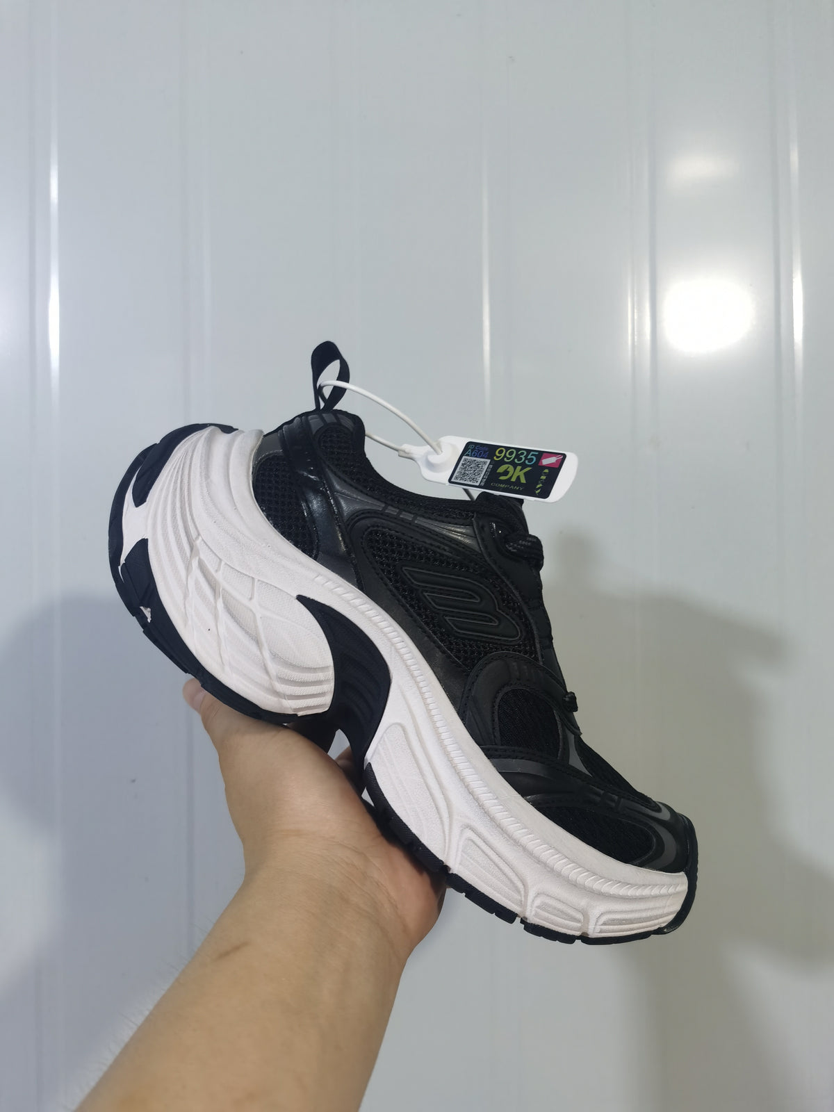 Black and white Skechers sneaker shown from the outer side, highlighting the layered upper and sculpted white midsole.