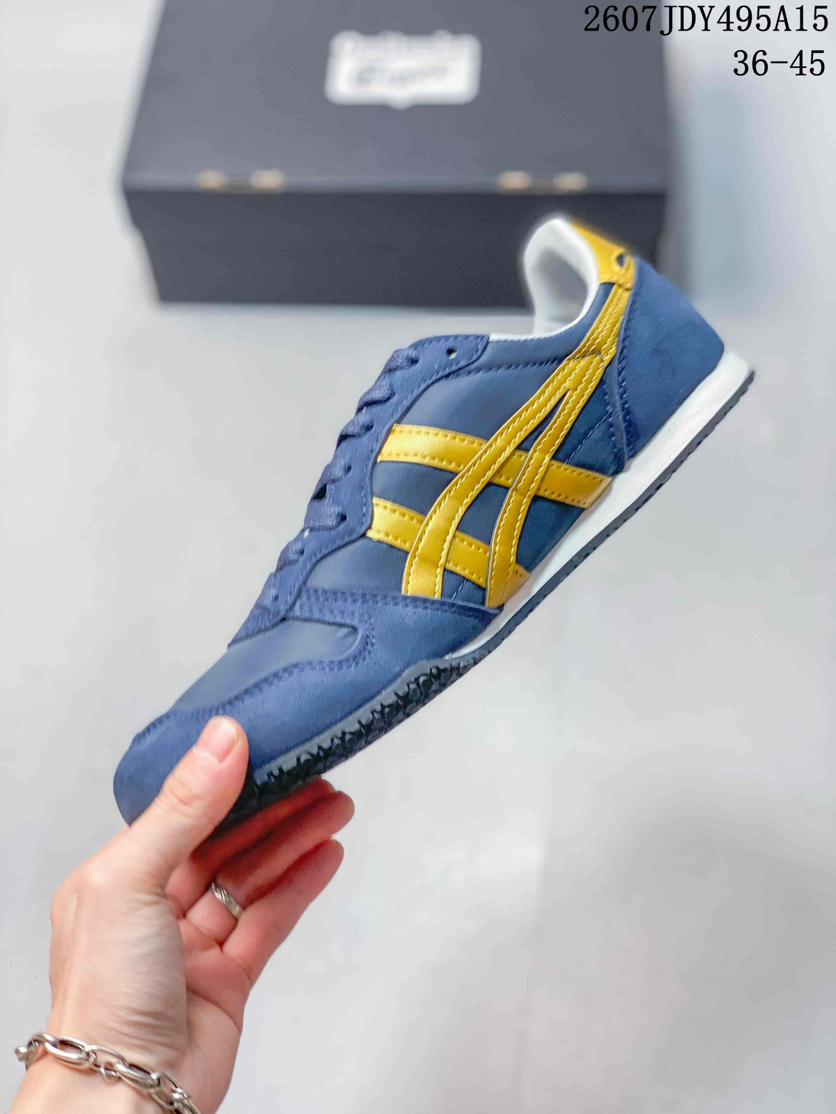 Side profile of a blue and yellow Onitsuka Tiger sneaker showing the layered side stripes, lace-up upper, white midsole, and dark outsole; image text shows size range 36-45.