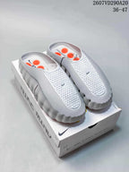 White Nike Mind 001 covered-toe slides displayed on a product box, with style code 2607VD290A20 and size range 36–47 visible.