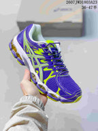 Purple and neon green ASICS Gel-Nimbus 16 sneaker held against a shoebox.