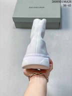 Rear view of a white sock sneaker showing the raised ankle collar, heel branding and segmented sole.