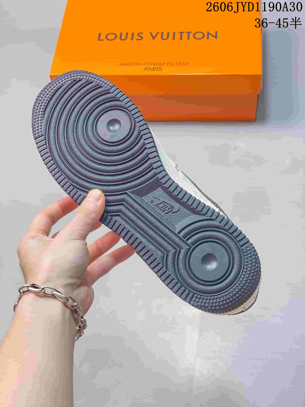 View of the sneaker's dark gray outsole with circular tread details.