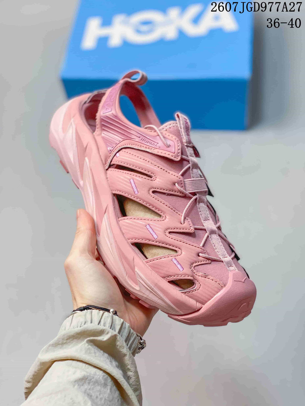 Angled side view of a pink HOKA Hopara sandal with heel strap, side cutouts and lugged outsole; overlay shows size range 36–40.
