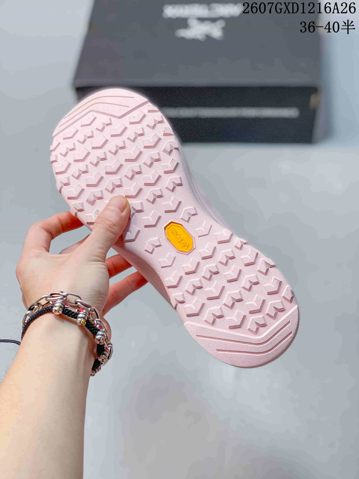 Underside of the pink shoe showing a repeating lug pattern and a yellow Vibram-branded insert.