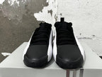 Front view of black and white Adidas basketball shoes with lace-up closures.