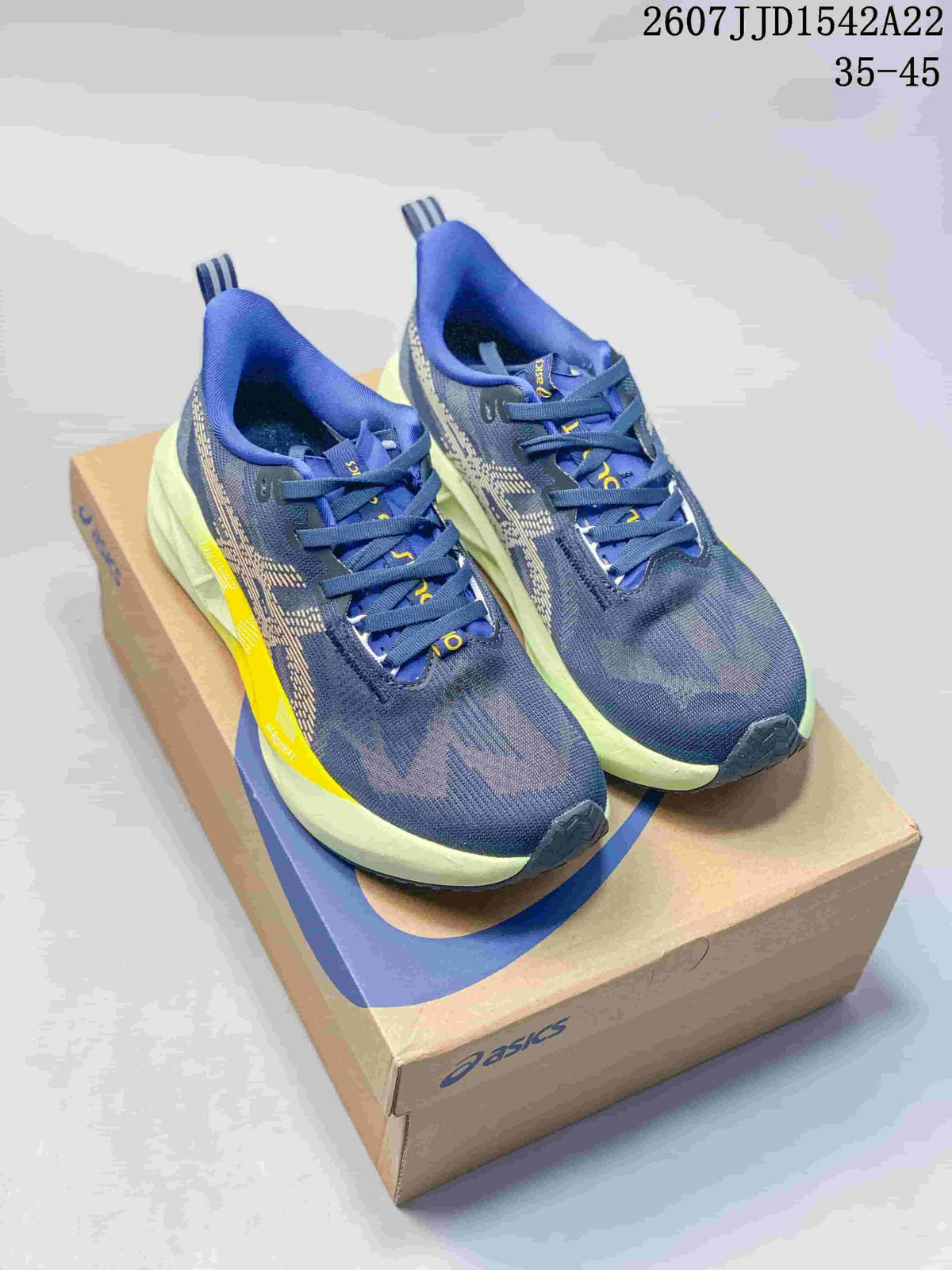 Pair of navy and lime ASICS GEL-NOVABLAST 5 LE running shoes displayed on an ASICS shoebox; image text shows style code 2607JJD1542A22 and size range 35-45.