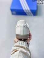 Rear view showing the white heel, padded collar, stitching, and gum-colored outsole edge.