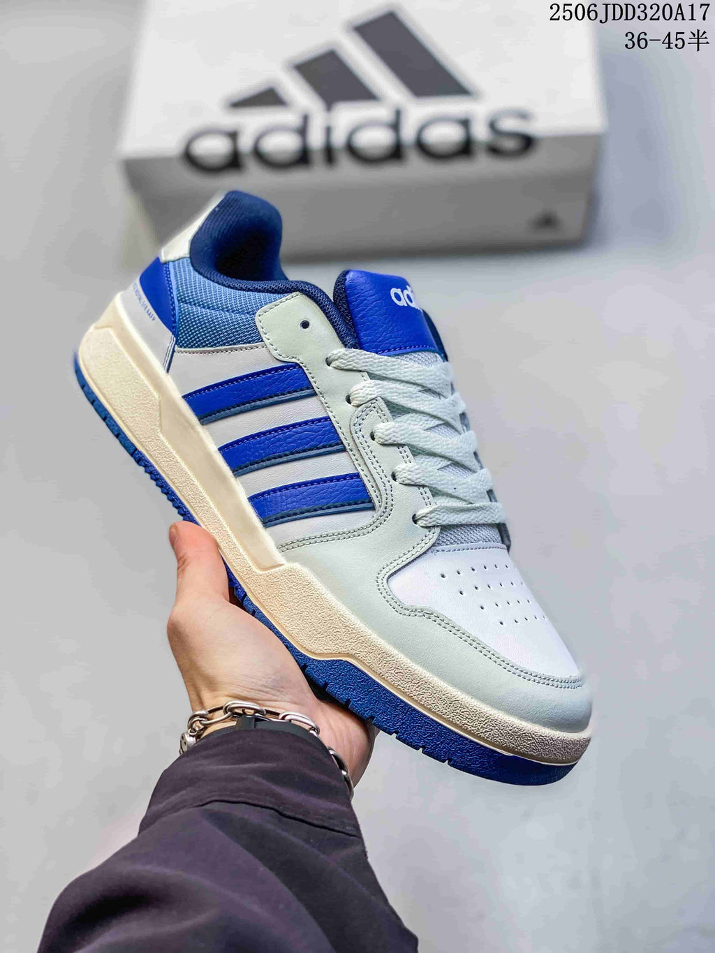 Angled side view of the white and royal blue adidas Entrap sneaker showing the lace-up construction and textured blue outsole.