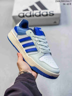 Angled side view of the white and royal blue adidas Entrap sneaker showing the lace-up construction and textured blue outsole.