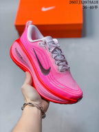Angled side view of the pink and red sneaker showing the lace-up upper, Nike Swoosh and ZoomX branding.