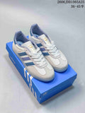 Pair of white adidas Gazelle sneakers with blue and lavender stripes displayed on a blue adidas shoebox.