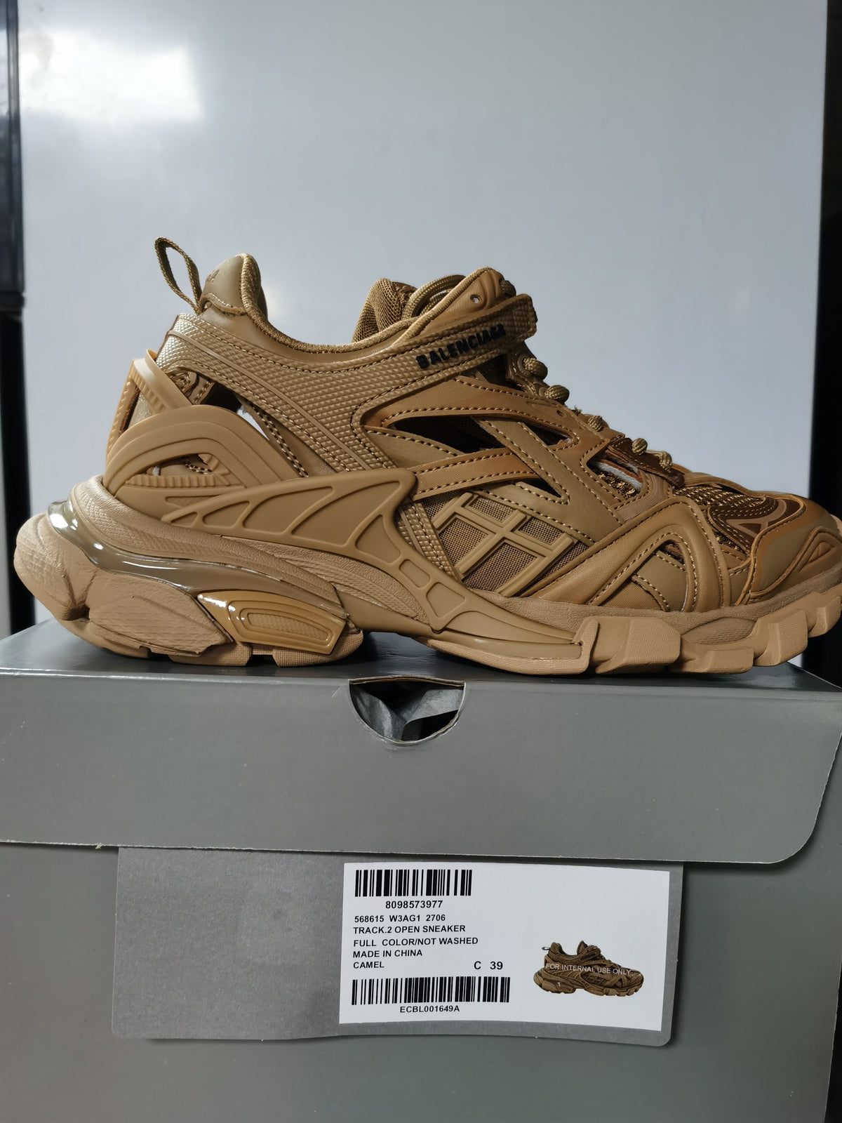 Camel Balenciaga Track.2 open sneaker shown in profile above its box, with the box label visible.