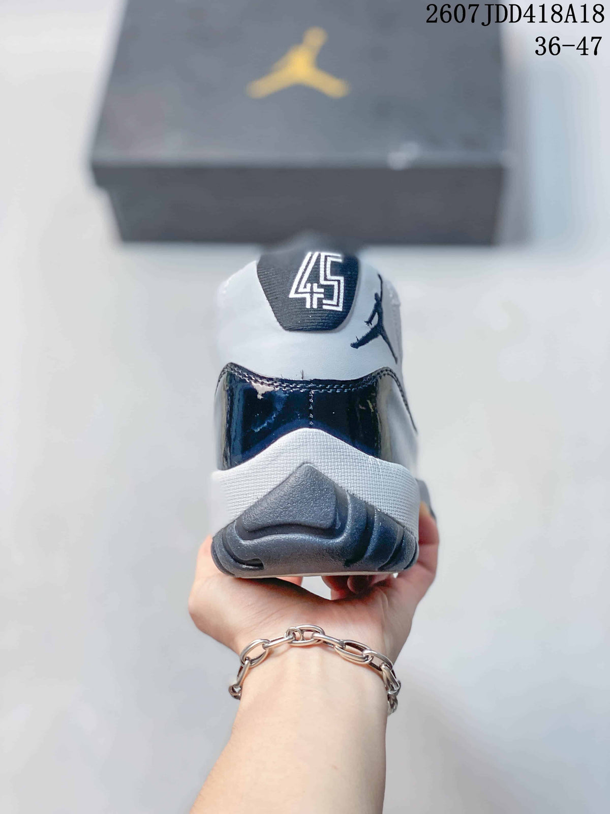 Rear view of the sneaker showing the padded collar, heel branding and dark navy heel panel.