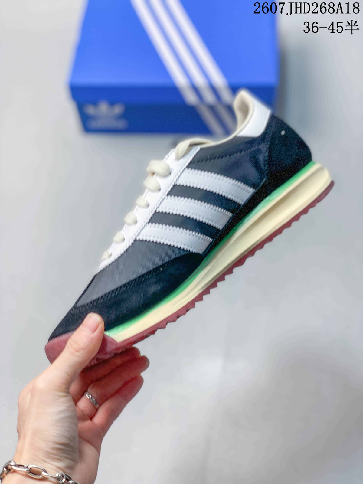 Side profile showing the navy upper, white three stripes, cream midsole, green accent, and burgundy outsole.