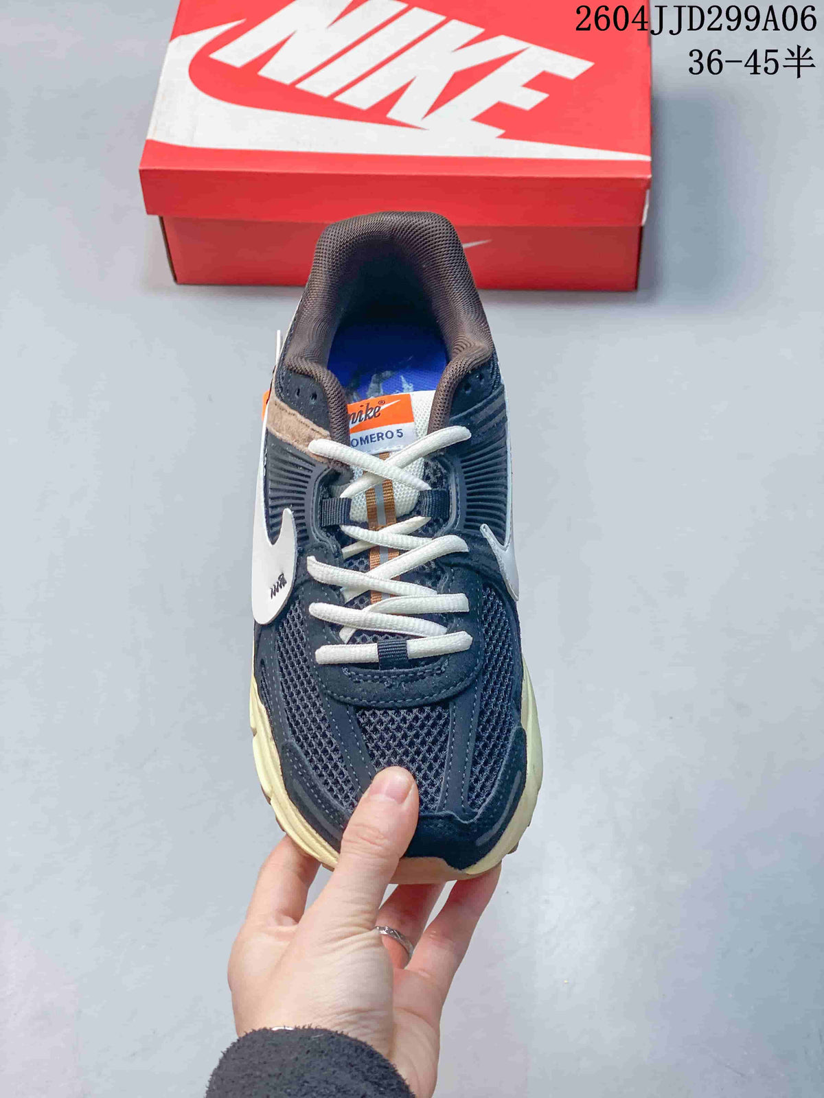 Top view of the navy sneaker showing white laces, mesh panels, and the Vomero 5 tongue label.