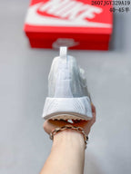 Rear view of the white sneaker showing the heel pull tab, padded collar, and textured heel section.