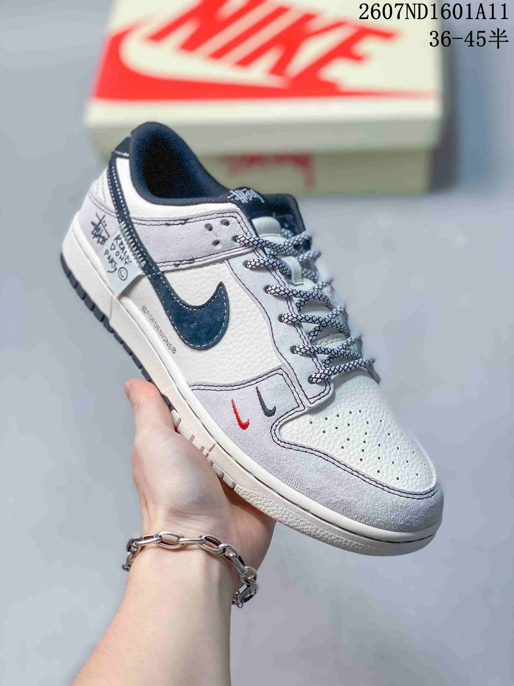 Angled side view highlighting the white and navy Swoosh, graphic side-panel accents, patterned laces, and low-top shape.