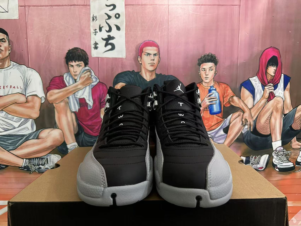 Front view of black and grey Jordan 12 sneakers with black laces