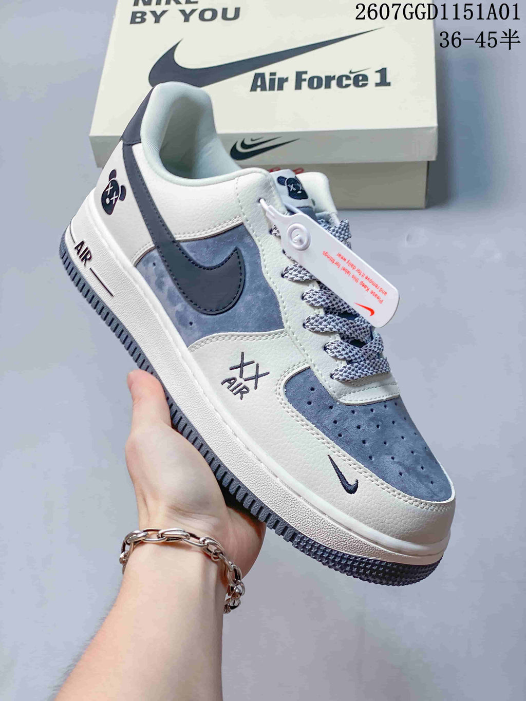 Close-up angled view of white and blue-gray sneakers with contrast Swooshes