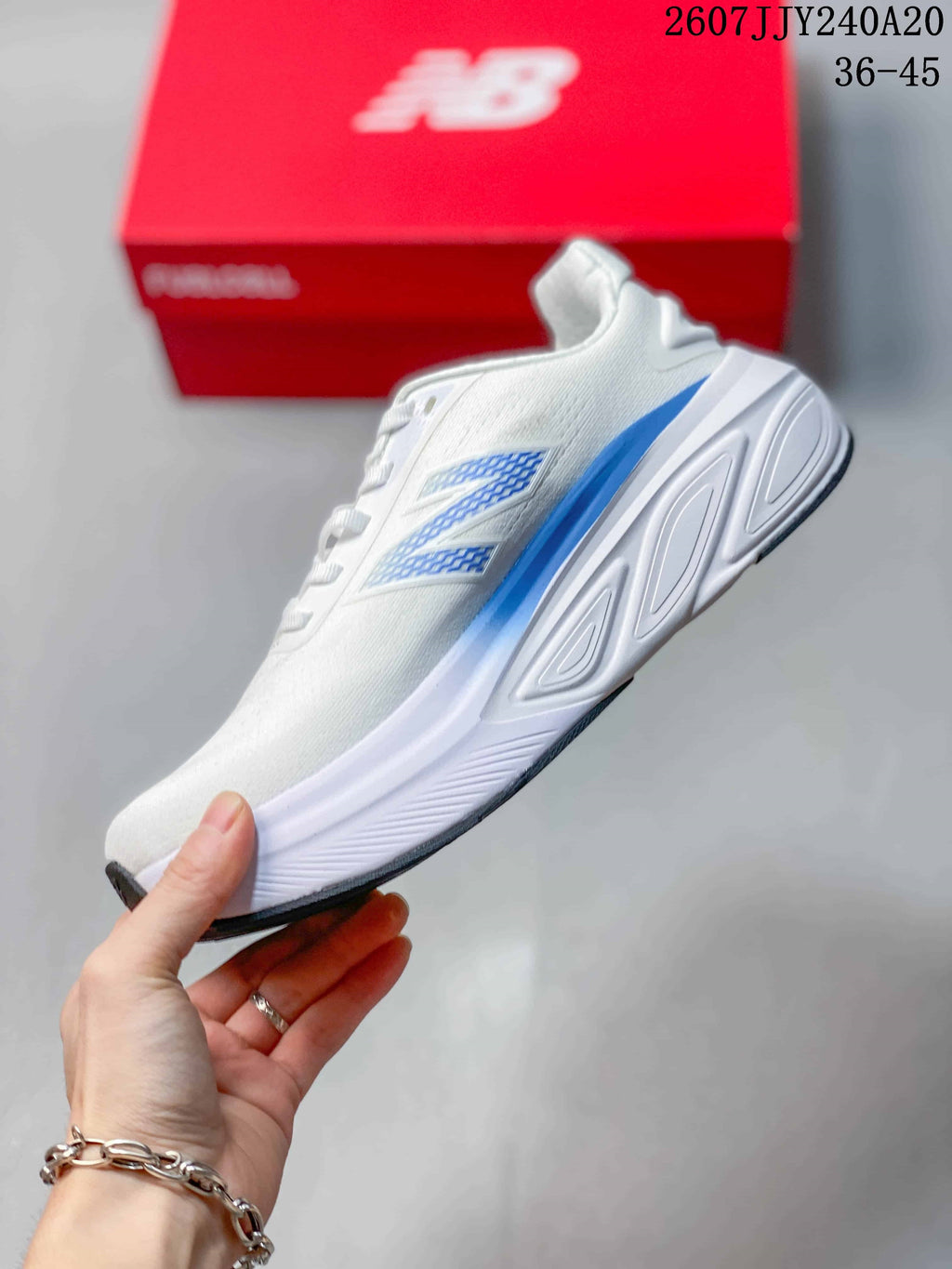 Side profile showing the white upper, blue side detail and sculpted midsole.