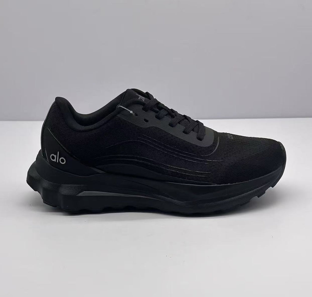 Side profile of an all-black Alo lace-up sneaker showing the layered upper, padded collar, and thick outsole.