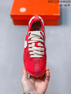 Top view of the red sneaker showing cream laces, stitched panels, and the low-top silhouette.