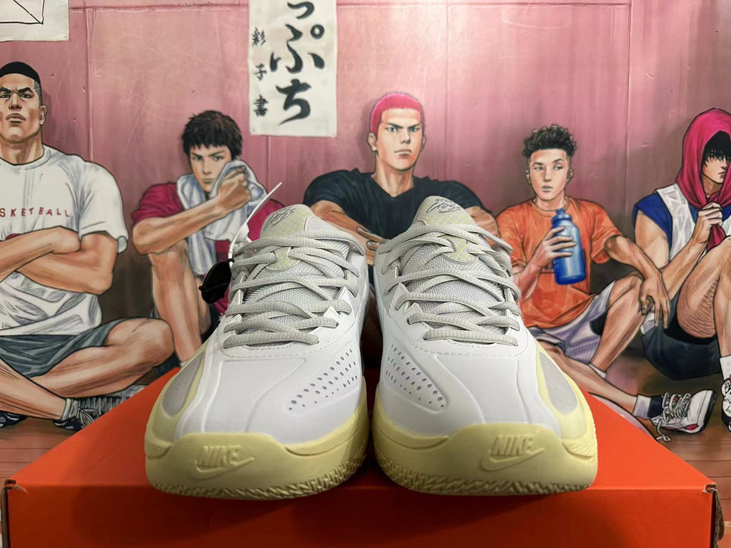 Front view of gray Nike basketball shoes with pale yellow details and lace-up closure.