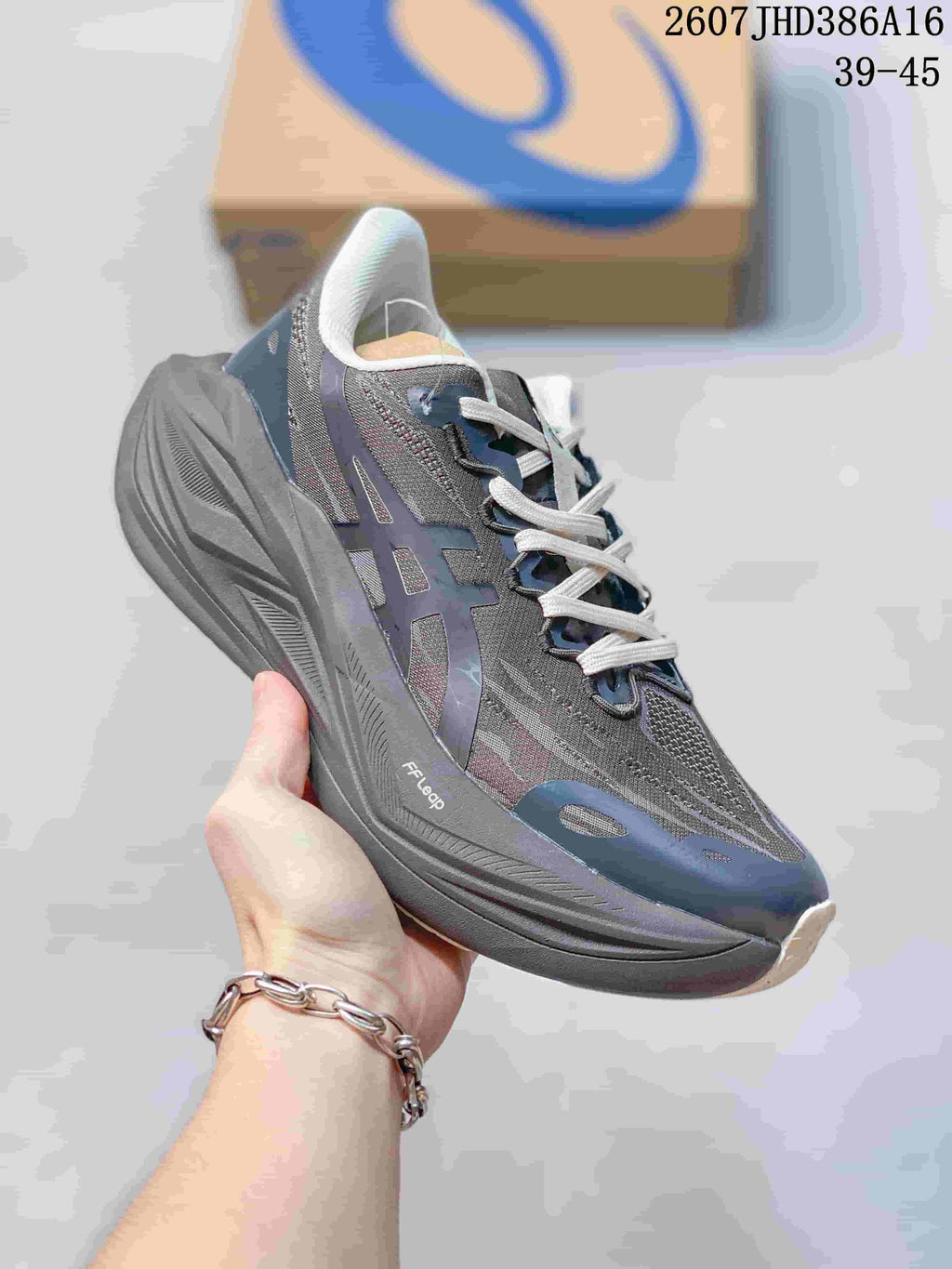 Side view of a gray and navy ASICS running sneaker showing the layered upper, sculpted sole, and visible FF BLAST marking; image text shows 2607JHD386A16 and 39–45.