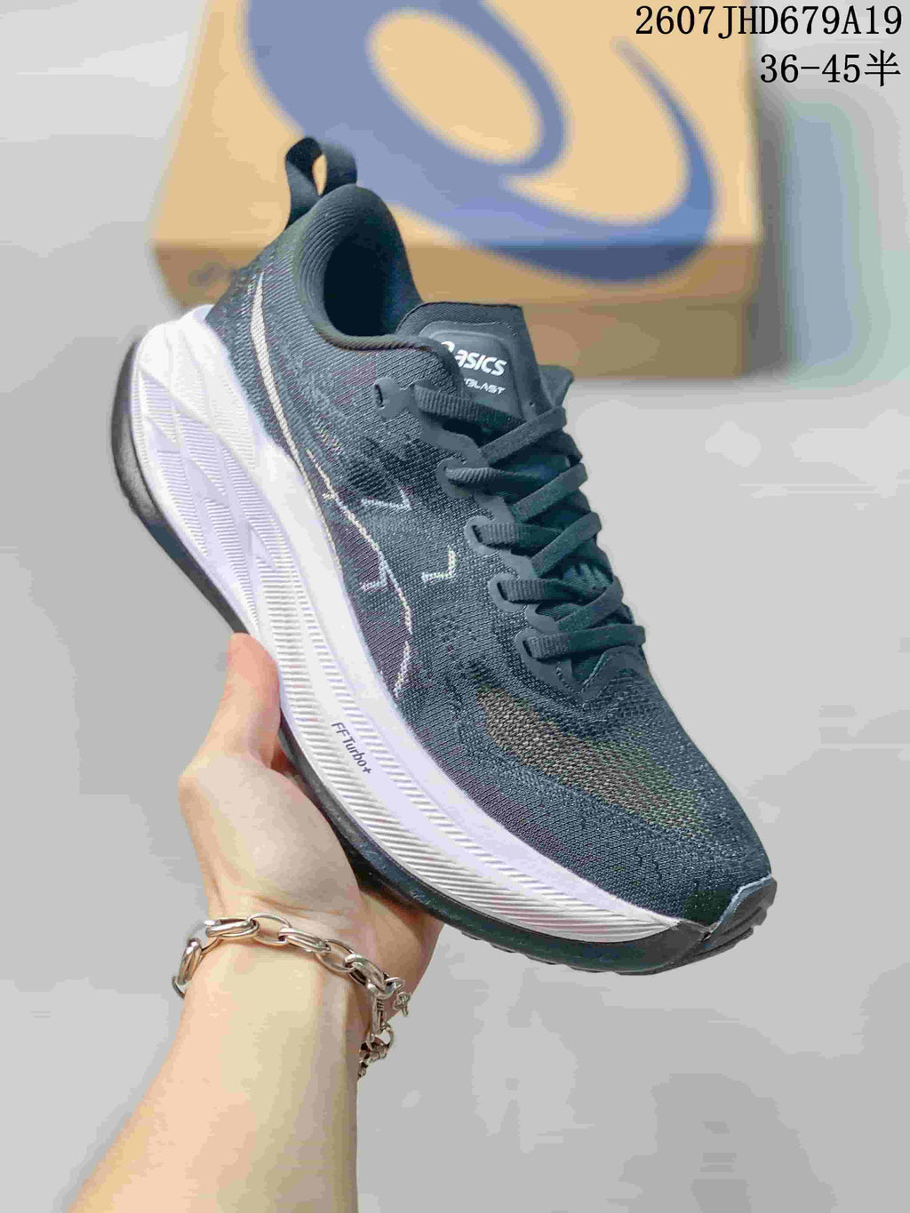 Angled side view showing the dark upper, ASICS branding, white midsole and black outsole.