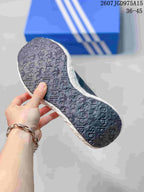 Bottom view showing the dark patterned outsole and textured white midsole of the sneaker.