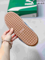 Close view of the gum-colored outsole showing a repeating geometric traction pattern; a green PUMA shoe box is in the background.