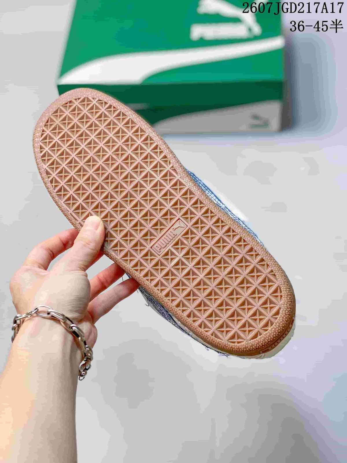Close view of the gum-colored outsole showing a repeating geometric traction pattern; a green PUMA shoe box is in the background.