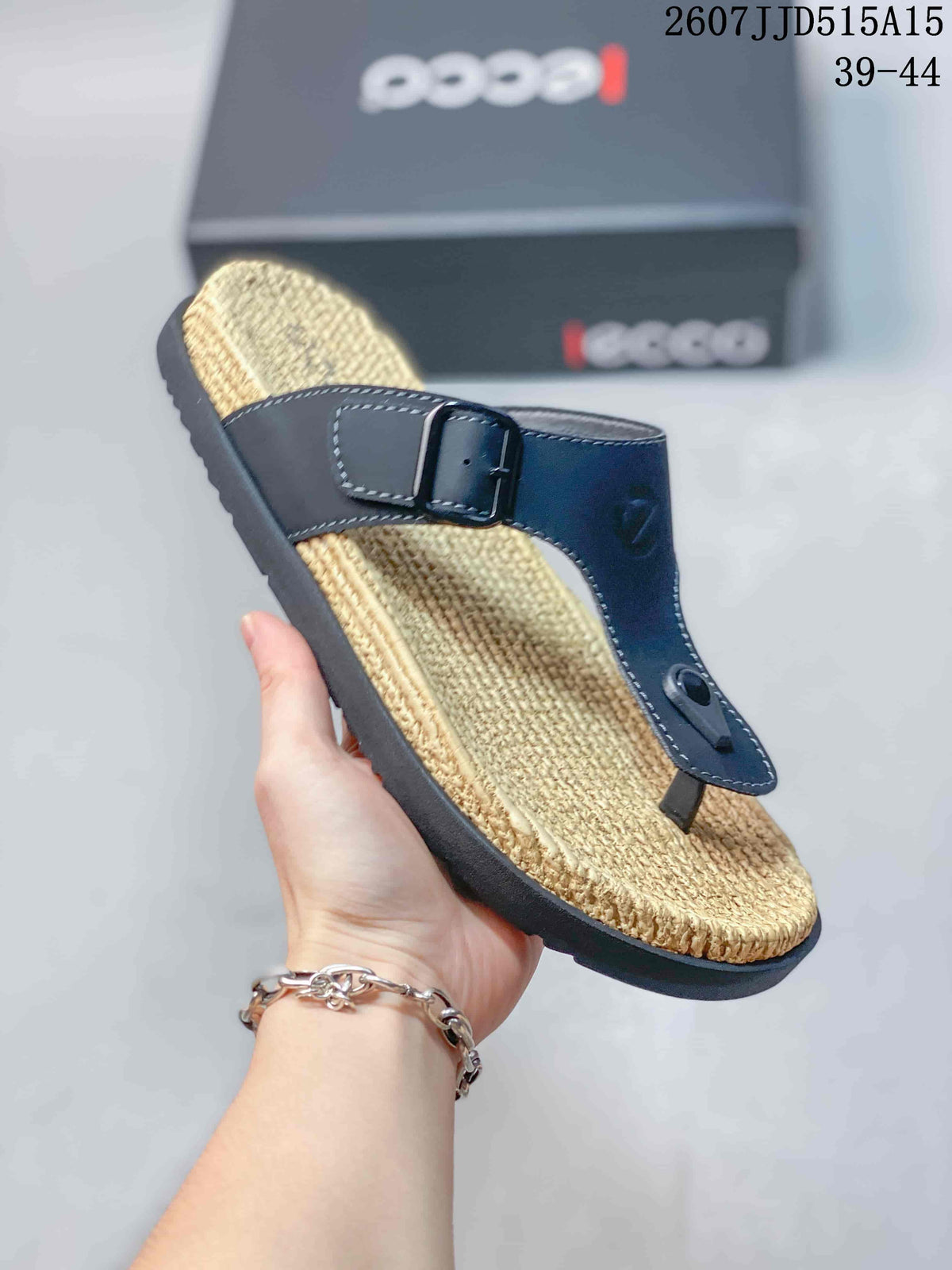 Close-up of a black toe-post sandal highlighting the buckle strap, stitched upper, toe post, and textured footbed.