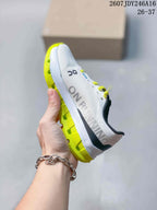 Side view of a white On shoe with large side branding, lime outsole elements, and lace-up closure.