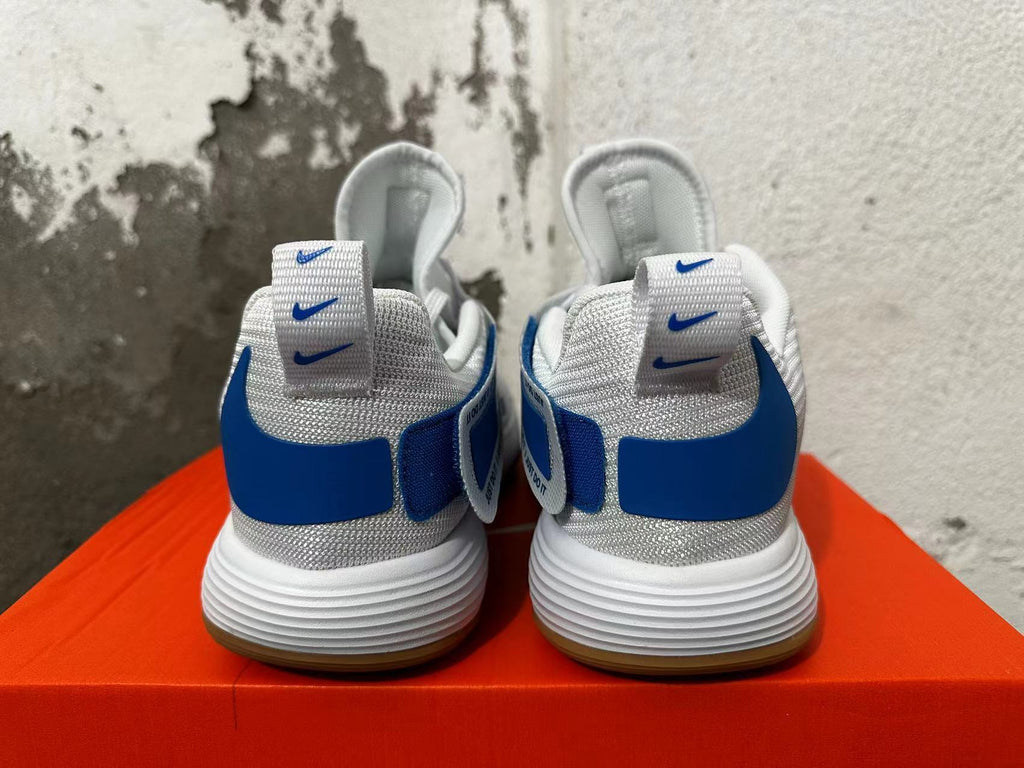 Rear view of white and blue Nike basketball shoes showing textured collars and heel details.