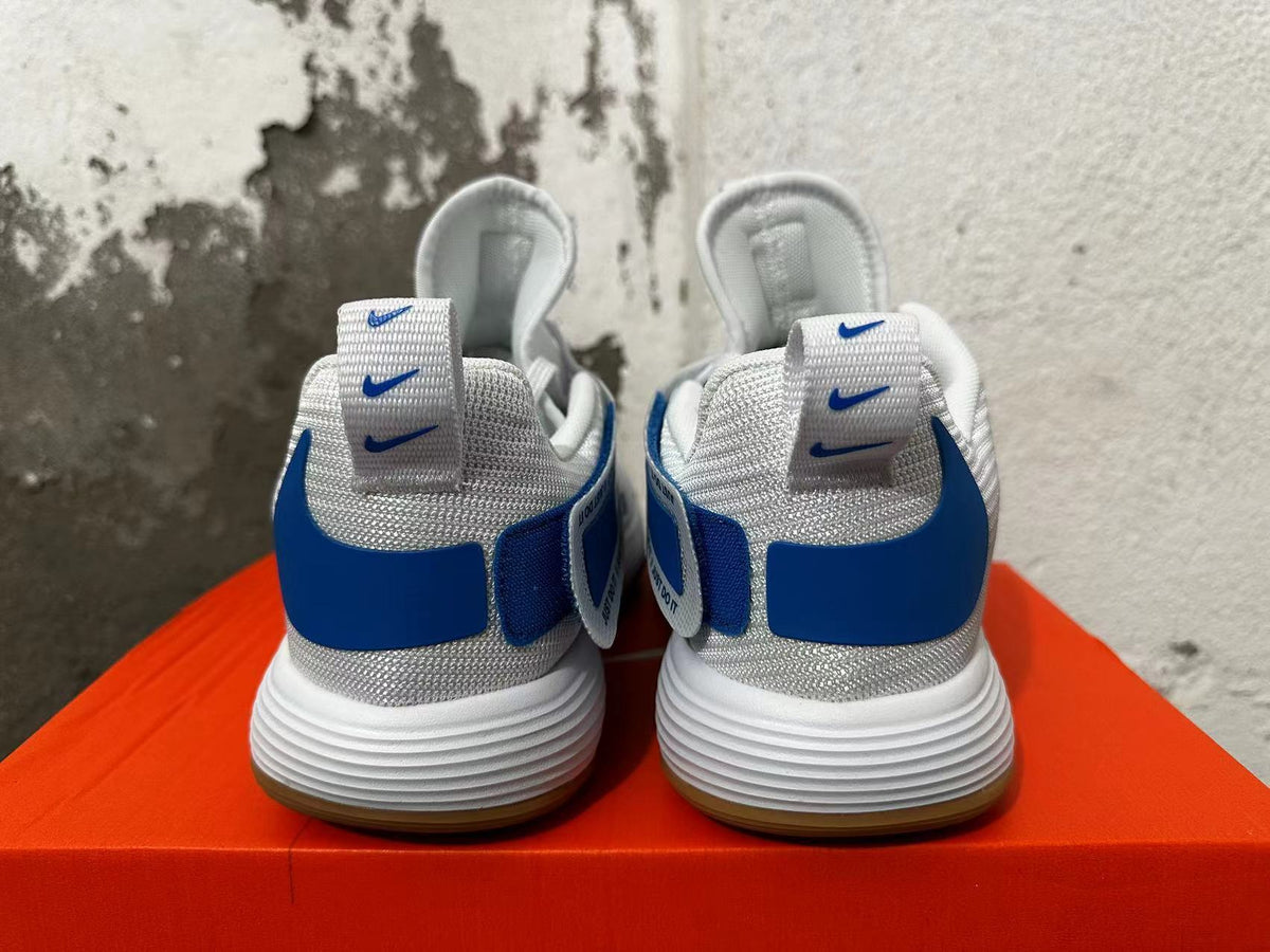 Rear view of white and blue Nike basketball shoes showing textured collars and heel details.