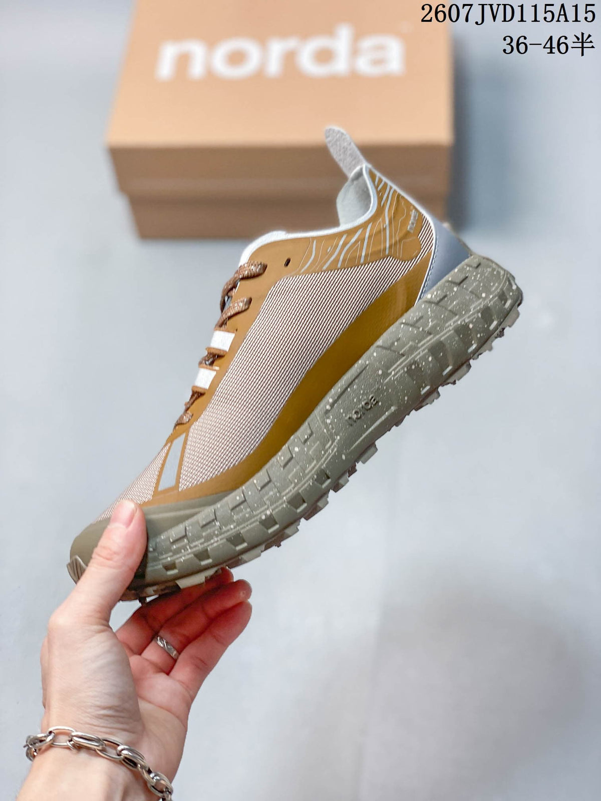 Side view of the mustard and beige sneaker with contrasting upper panels and a rugged gray outsole.