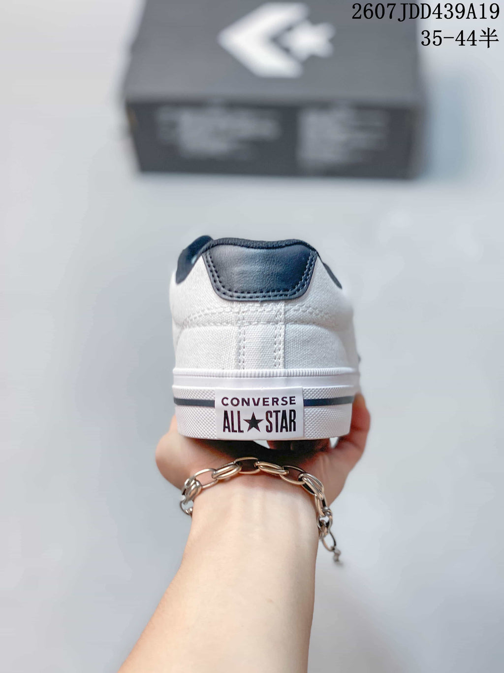 Rear view of the white sneaker showing the dark collar and Converse All Star heel branding.