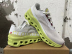 Angled view of gray running shoes with lime-green soles